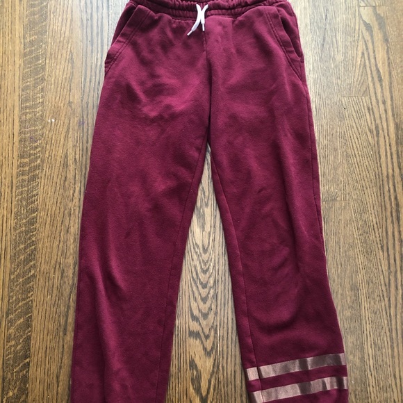 These are red sweatpants with two gold stripes. - Picture 1 of 4